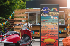 red scooter and food truck with colorful flags behind
